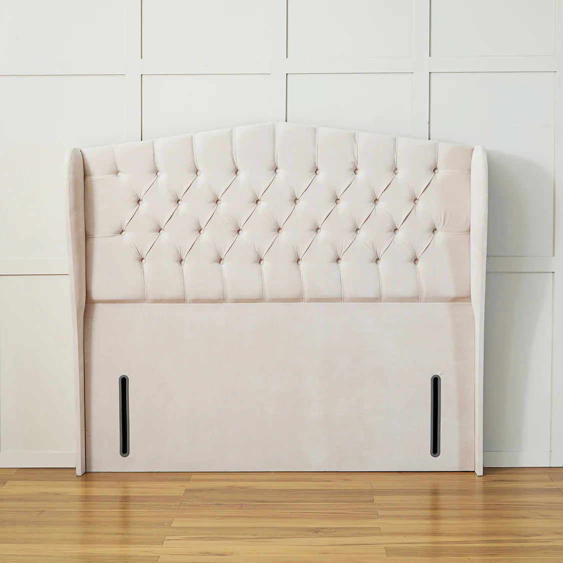 Handmade UK SleepandBeds wing panel headboard attached to a bed frame, showcasing its elegant design and soft fabric upholstery.